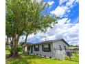 Charming single-story home with a well-manicured lawn, wrought iron fence, and mature shade tree at 4469 Evers Pl, Orlando, FL 32811