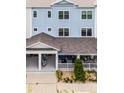 Three-story townhouse showcasing the blue siding and covered front porch at 461 Diamond Dove Cv, Winter Springs, FL 32708