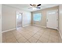 Living room with tile flooring, a ceiling fan, and a welcoming front door at 4757 Goldsboro Ct, Orlando, FL 32811