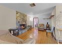 Cozy living room boasts a stone fireplace and hardwood floors at 500 E Gottsche Ave, Eustis, FL 32726