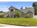 Well-maintained single-Gathering home showcasing lush landscaping, a gray facade, and a welcoming entrance for a serene setting at 645 Macglenross Dr, Oviedo, FL 32765