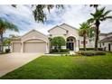 Beautiful single-Gathering home featuring a well-manicured lawn, mature trees, and a two-car garage at 697 Broadoak Loop, Sanford, FL 32771