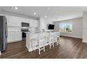 Modern kitchen with white cabinets, stainless appliances, and island with white stools at 7367 Catania Loop, Clermont, FL 34714