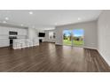Open-concept living room boasts hardwood floors, lots of natural light, and kitchen with stainless appliances at 7367 Catania Loop, Clermont, FL 34714