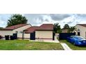 Charming single-Gathering home with a well-manicured lawn and a side entrance, complemented by dark fencing at 761 Golden Sunshine Cir, Orlando, FL 32807