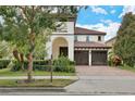 Charming two-story home with lush landscaping and a red tile roof has great curb appeal in a lovely neighborhood at 8752 Lookout Pointe Dr, Windermere, FL 34786