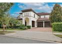 Beautiful two-story home boasts a charming facade, lush landscaping, brick paver driveway and a two-car garage at 8752 Lookout Pointe Dr, Windermere, FL 34786