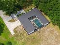 Aerial view of home featuring screened in pool, surrounded by green lawns and mature trees at 9353 Gotha Rd, Windermere, FL 34786