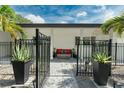 Stylish entrance featuring a black fence, potted plants, stone walkway, and a cozy bench at 9353 Gotha Rd, Windermere, FL 34786