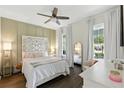 Comfortable bedroom with a statement headboard, soft lighting, and large windows with backyard views at 16262 Firedragon Dr, Winter Garden, FL 34787
