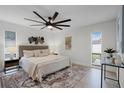 Serene main bedroom featuring a plush bed, stylish decor, a ceiling fan and ample natural light at 2932 Carriage Dr, South Daytona, FL 32119