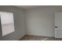 Well-lit bedroom with wood-look floors and window with horizontal blinds at 311 Osceola Ave, Lake Wales, FL 33853