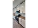 Modern kitchen featuring stainless steel appliances, white cabinets and geometric backsplash at 4009 Serene Water Ave, Eustis, FL 32736