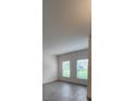 Bright living room featuring light grey flooring and two windows offering pleasant outdoor views at 4009 Serene Water Ave, Eustis, FL 32736