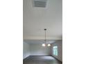 Open-concept living room with wood-look tile flooring and a decorative light fixture at 4009 Serene Water Ave, Eustis, FL 32736