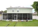 Spacious screened lanai in backyard with green lawn; solar panels on roof at 115 Willowbay Ridge St, Sanford, FL 32771