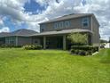 Expansive backyard with lush lawn, covered patio, and neatly trimmed landscaping at 1166 Heron Sound Dr, Apopka, FL 32703