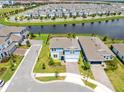 Aerial view of the blue two-story home showcasing its position near a pond and manicured landscaping at 13829 Destin Beach Ln, Orlando, FL 32827