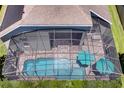 Aerial view of screened pool with two teal umbrellas and deck furniture, surrounded by green grass at 15521 Sandfield Loop, Winter Garden, FL 34787
