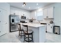 Bright kitchen featuring white cabinets, stainless steel appliances, and a center island with seating at 2043 Rock Maple Bnd, Kissimmee, FL 34746