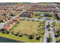 An aerial view of a meticulously planned community, showcasing homes, a pool, a playground, and green spaces at 2122 Bent Grass Ave, Ocoee, FL 34761