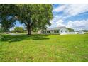 Well-kept single-story home featuring a spacious lawn, dark roof, and complemented by a mature shade tree at 2190 Northland Rd, Mount Dora, FL 32757