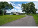 Beautiful single-story home with a well-maintained lawn, long driveway, mature trees, and white picket fence at 2190 Northland Rd, Mount Dora, FL 32757