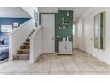 Inviting entryway featuring stylish decor, modern tile flooring, and staircase access at 2662 Roadster Ln, Kissimmee, FL 34746