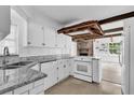 Bright kitchen with granite countertops, white cabinets, and open view of the dining area at 317 Benton St, Orlando, FL 32839
