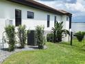Landscaped backyard featuring an air conditioning unit, lush plants, and a black fence bordering the property at 4073 Juliana Lake Dr, Auburndale, FL 33823