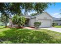 Well maintained single story home with lush green lawn and mature trees at 5671 Sycamore Canyon Dr, Kissimmee, FL 34758