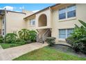 Condo exterior with plants, grassy areas, wooden steps and an arched entry way at 754 E Michigan St # 182, Orlando, FL 32806