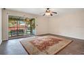 Living room with a ceiling fan, carpeted floor, sliding doors leading to balcony and pool view at 754 E Michigan St # 182, Orlando, FL 32806