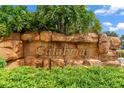 A welcoming stone sign for the Calabria community surrounded by lush, tropical plants and landscaping at 9110 Stromboli Ct, Kissimmee, FL 34747