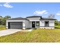 Charming single-story home with a gray garage door, black trim and a well-manicured lawn and inviting curb appeal at 15684 Sw 37Th Cir, Ocala, FL 34473