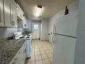 Functional kitchen with white cabinets, granite countertops, and essential appliances at 220 Cherokee Ct # 116, Altamonte Springs, FL 32701