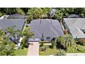 Aerial view of a single-story home with lush tropical landscaping and a brick-paved driveway at 2342 Northumbria Dr, Sanford, FL 32771