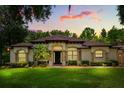 Charming one-story home with a lush green lawn, palm tree, and neutral paint scheme at 25910 Timuquana Dr, Sorrento, FL 32776
