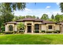 Stunning single-story home featuring manicured lawn, a dark front door, and mature landscaping at 25910 Timuquana Dr, Sorrento, FL 32776