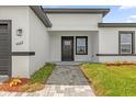 The modern home features a front door with side light and manicured lawn at 4662 Sw 136Th St, Ocala, FL 34473