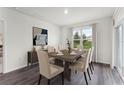 Bright dining room with a modern table, stylish chairs, and a large window overlooking the yard at 5120 Gopher Apple Dr, Apopka, FL 32712
