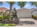 A spacious two-car garage adjacent to a screened lanai, surrounded by lush landscaping and mature trees at 7416 Soiree Way, Reunion, FL 34747