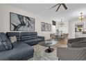 Modern living room with grey sofa, contemporary artwork, and adjacent dining area with seating for eight at 7416 Soiree Way, Reunion, FL 34747