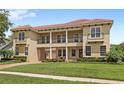 Beautiful two-story home featuring a tile roof, covered portico, landscaped lawn, and inviting second-story balconies at 8424 Lake Burden Cir, Windermere, FL 34786