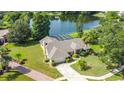 Aerial view of home with pool, lush landscaping, and lake view at 1125 Almond Tree Cir, Orlando, FL 32835
