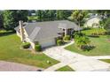 Stunning exterior view of home with landscaped yard, lake, and driveway at 1125 Almond Tree Cir, Orlando, FL 32835