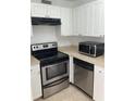Modern kitchen featuring stainless steel appliances, white cabinets, and neutral countertops at 2525 Caper Ln # 205, Maitland, FL 32751