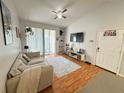 Bright living room with vaulted ceiling, laminate floors, balcony access, and stylish decor at 2740 Maitland Crossing Way # 2-303, Orlando, FL 32810