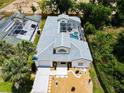An aerial view of the home, showing the screened-in pool, landscaping, tile roof, and proximity to neighboring homes at 3211 Sunrise Walk, Kissimmee, FL 34747
