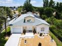 An aerial view of the property featuring a well-manicured lawn, tile roof, solar panels, and a two-car garage at 3211 Sunrise Walk, Kissimmee, FL 34747